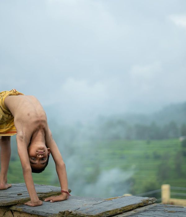 Person stretching gently outdoors with a serene landscape background.